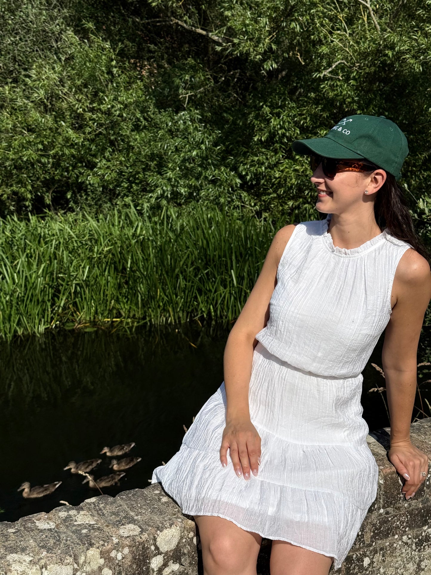 Woman wearing Tadhg & Co forest green cap made from premium materials, designed for everyday wear with a classic British country aesthetic.