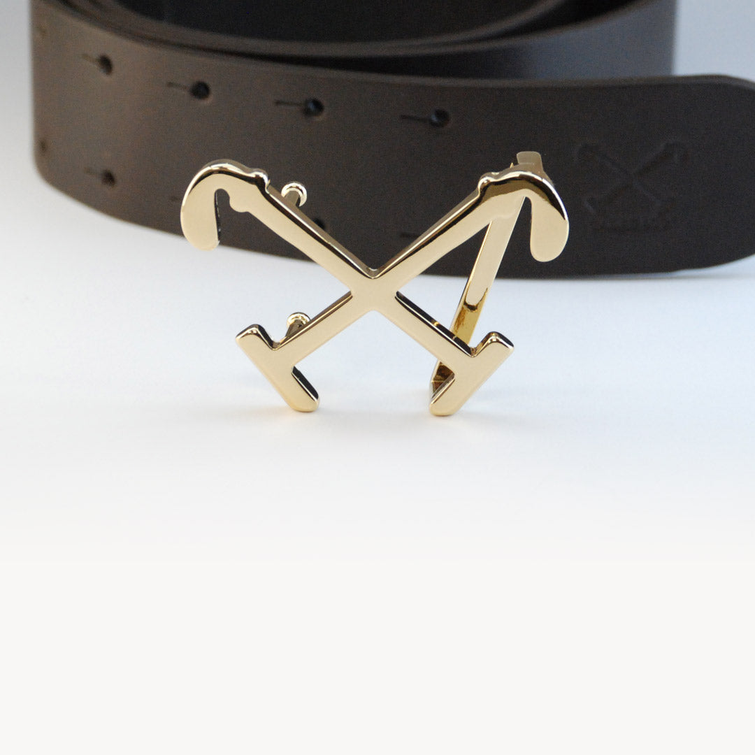 The Tadhg Signature Buckle in front of leather strap.